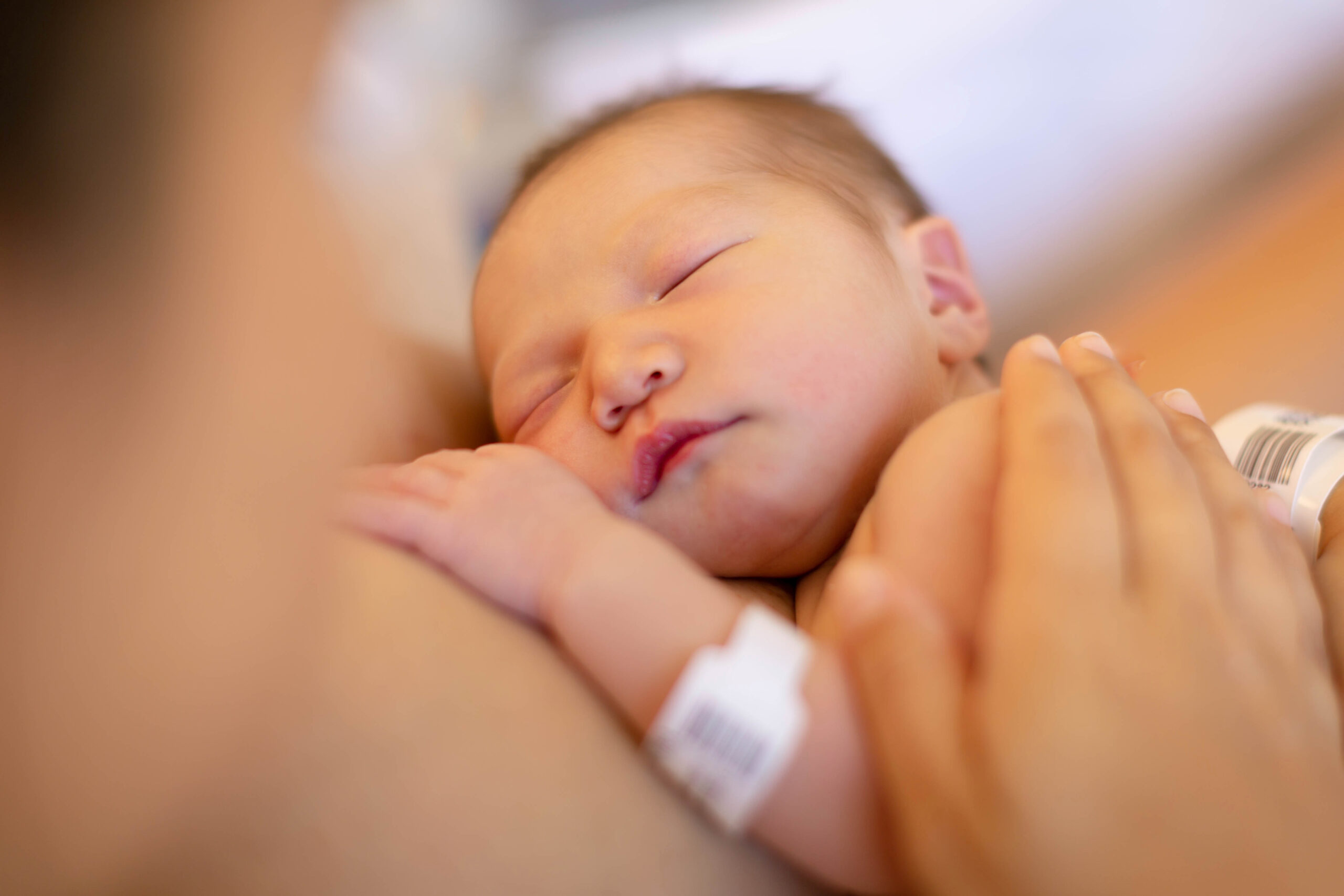 mother holding sleeping newborn baby